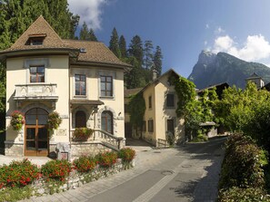 Ein traditionelles Gebäude im europäischen Stil mit einer Steinaußenseite, mehreren Fenstern und einem Balkon.