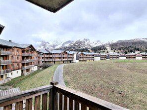 A wooden lodge with multiple balconies and a view of snow-capped mountains. - Apartment for 8 with balcony, near shops and slopes, ski locker (Le Dévoluy)