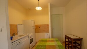 A compact kitchen with a dining table, a refrigerator, a stove, and a sink. - Charming Quiet House Near Sarlat with Fireplace and Terrace (Tursac)