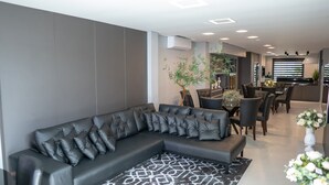 A modern living room with a sectional sofa, dining area, and kitchen in the background.