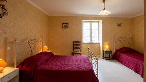 A bedroom with two beds, a window, a chair, and a nightstand with a lamp. - Isolated house with fireplace, pets allowed, near historical sites (Villac)