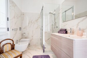 A bathroom with a shower, toilet, and vanity.