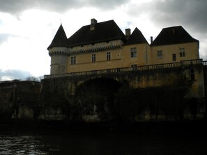 A large, historic building with a prominent tower and a bridge leading to it.