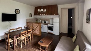 A compact living space with a dining area, kitchenette, and a sofa. - Charming village house near Villefranche du Périgord, pets allowed, internet included (Loubejac)