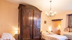 A bedroom with two beds, a large wooden wardrobe, a chandelier, and a small bedside table with a lamp. - Charming village house near Villefranche du Périgord, pets allowed, internet included (Loubejac)