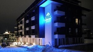 Un immeuble à plusieurs étages, sur lequel on peut voir une enseigne bien visible indiquant « ASPEN ».