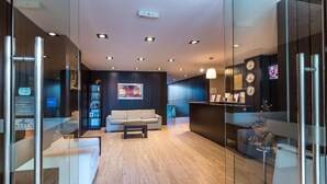 Un hall d’entrée moderne avec un canapé, une table basse et un comptoir d’accueil.