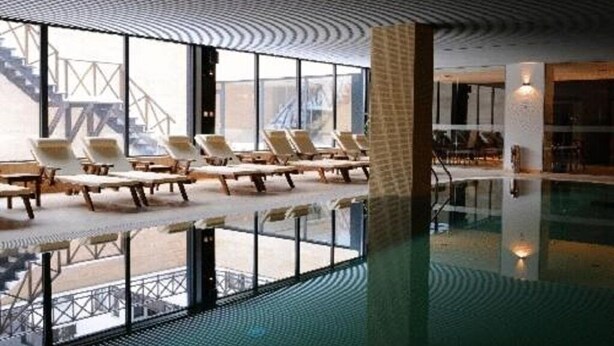 Un espace piscine avec des chaises longues et une vue sur un pont à l’extérieur.