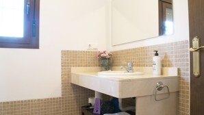 A bathroom with a sink, mirror, and tiled walls.