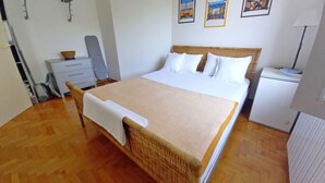 A bedroom with a bed, a dresser, a radiator, and framed pictures on the wall. - Holiday apartment Lungomare, only 300m from the beach (Pula)