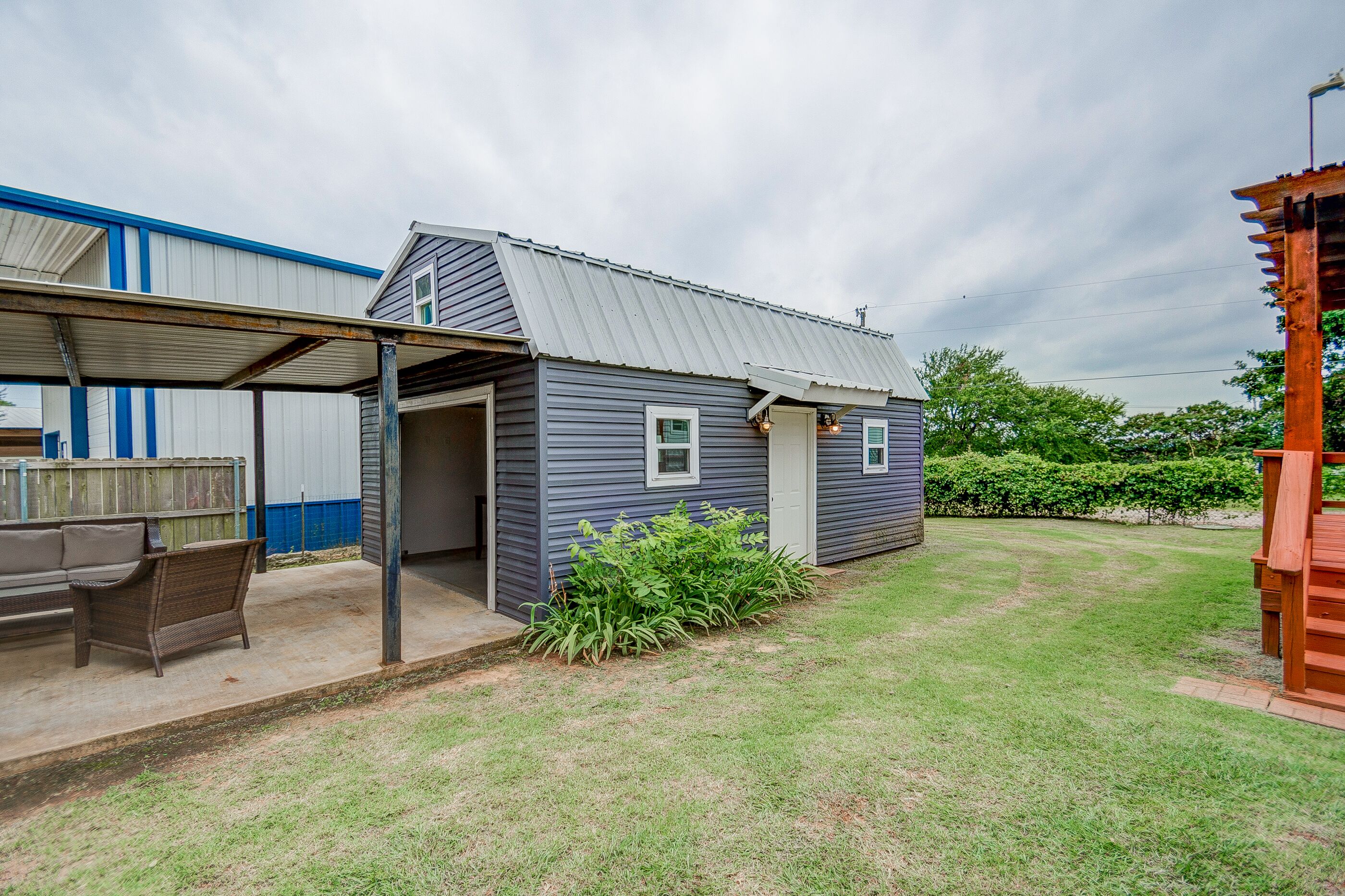A small, single-story house with a covered porch and a well-maintained lawn.