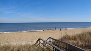 A beach with a wooden walkway leading to the shore. - Ocean Pines - 2BR/2BA Condo in Duck, NC (Duck)