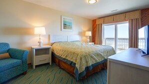 A hotel room with a bed, a desk, a chair, and a window with curtains. - Ocean Pines - 2BR/2BA Condo in Duck, NC (Duck)