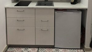 A compact kitchen with a built-in oven, a sink, and a dishwasher.