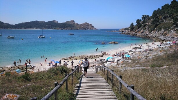A beach with a wooden walkway leading to the shore, surrounded by rocky terrain and clear blue water. - Villa Campo das Medas, in the middle of nature, with private salt pool (Donas Gondomar)