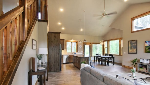 Una cocina amplia con una isla central, un comedor con una mesa grande y una sala de estar con sofá.