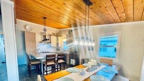 Une cuisine moderne avec des meubles en bois, un îlot central et des luminaires suspendus.