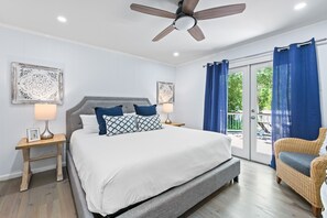 Relax in this serene bedroom with a large bed, bedside tables, and a ceiling fan.