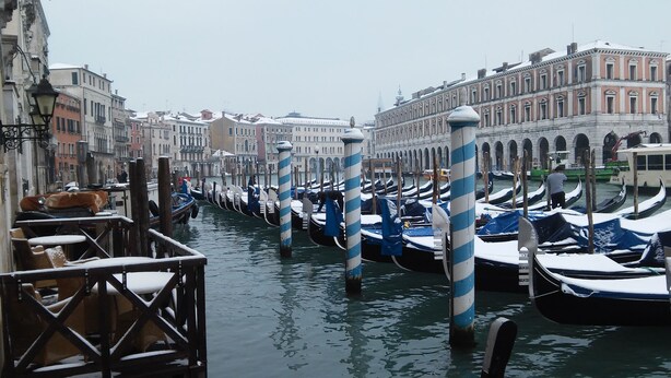 Un canal bordeado por barcos y edificios históricos.