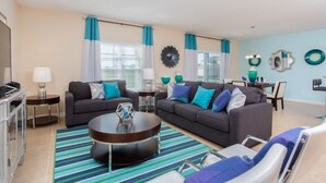 A living room with two sofas, a coffee table, and a dining area.