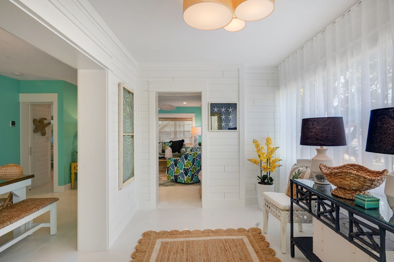 A hallway with a bench, a table with a lamp, and a decorative basket.