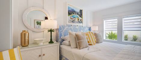 Un dormitorio con cama, mesita de noche, lámpara y ventana con persianas.