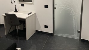 Une chambre moderne équipée d’un bureau, d’une chaise et d’une porte dont le vitrage est décoré.