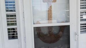 A white door with a window featuring a rope cross and a wreath. - Just  a 2 minute walk to the Atlantic Ocean!
 (Surf City)