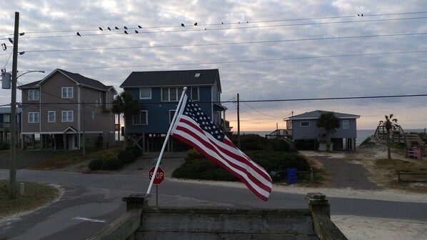 A residential area with houses, a stop sign, and an American flag. - Just a 2 minute walk to the Atlantic Ocean!
(Surf City)