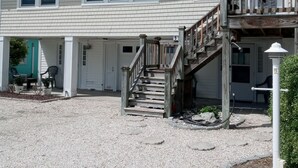 A two-story building with a covered porch, a wooden staircase, and an American flag. - Just  a 2 minute walk to the Atlantic Ocean!
 (Surf City)