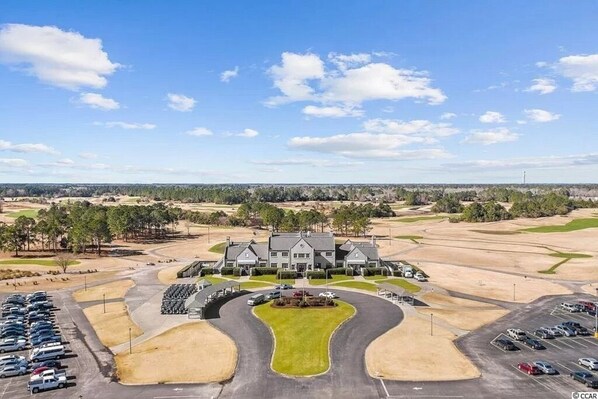 A large building with a central lawn, surrounded by parking areas and a golf course in the background. - 3 Bedroom Condo in Myrtle Beach (Myrtle Beach)