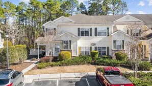 A two-story building with a central entrance, surrounded by parking spaces and greenery. - 3 Bedroom Condo in Myrtle Beach (Myrtle Beach)
