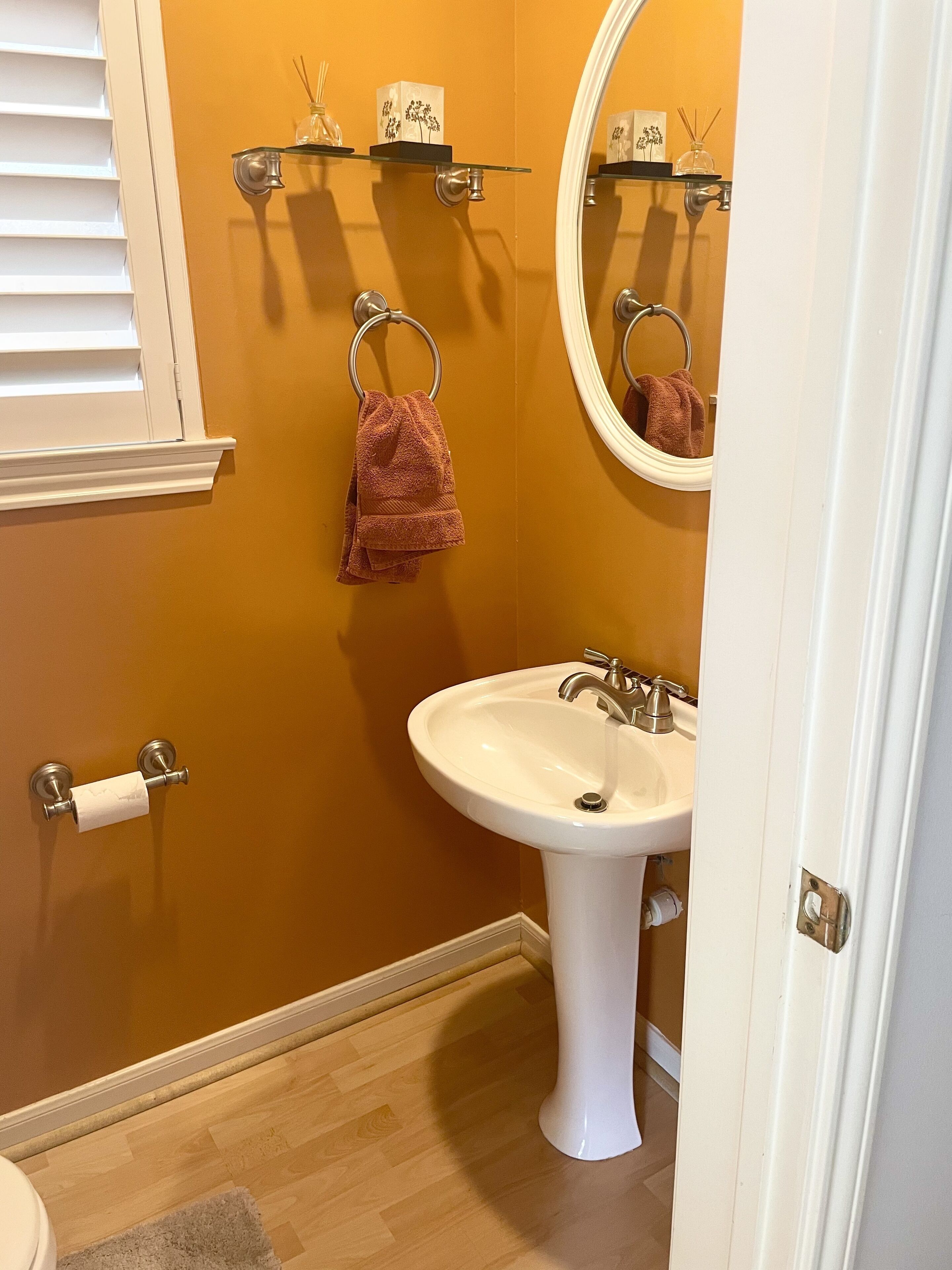 A bathroom with a white sink, a mirror, and a towel rack.