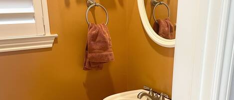 A bathroom with a white sink, a mirror, and a towel rack.
