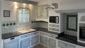 A kitchen with a built-in dishwasher, a microwave, and a stove. - Villa in the heart of Provence (Fuveau)