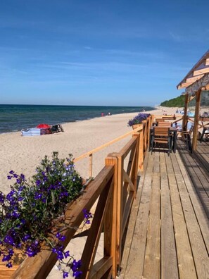 Una terraza de madera que da a una playa con una vista despejada del océano.