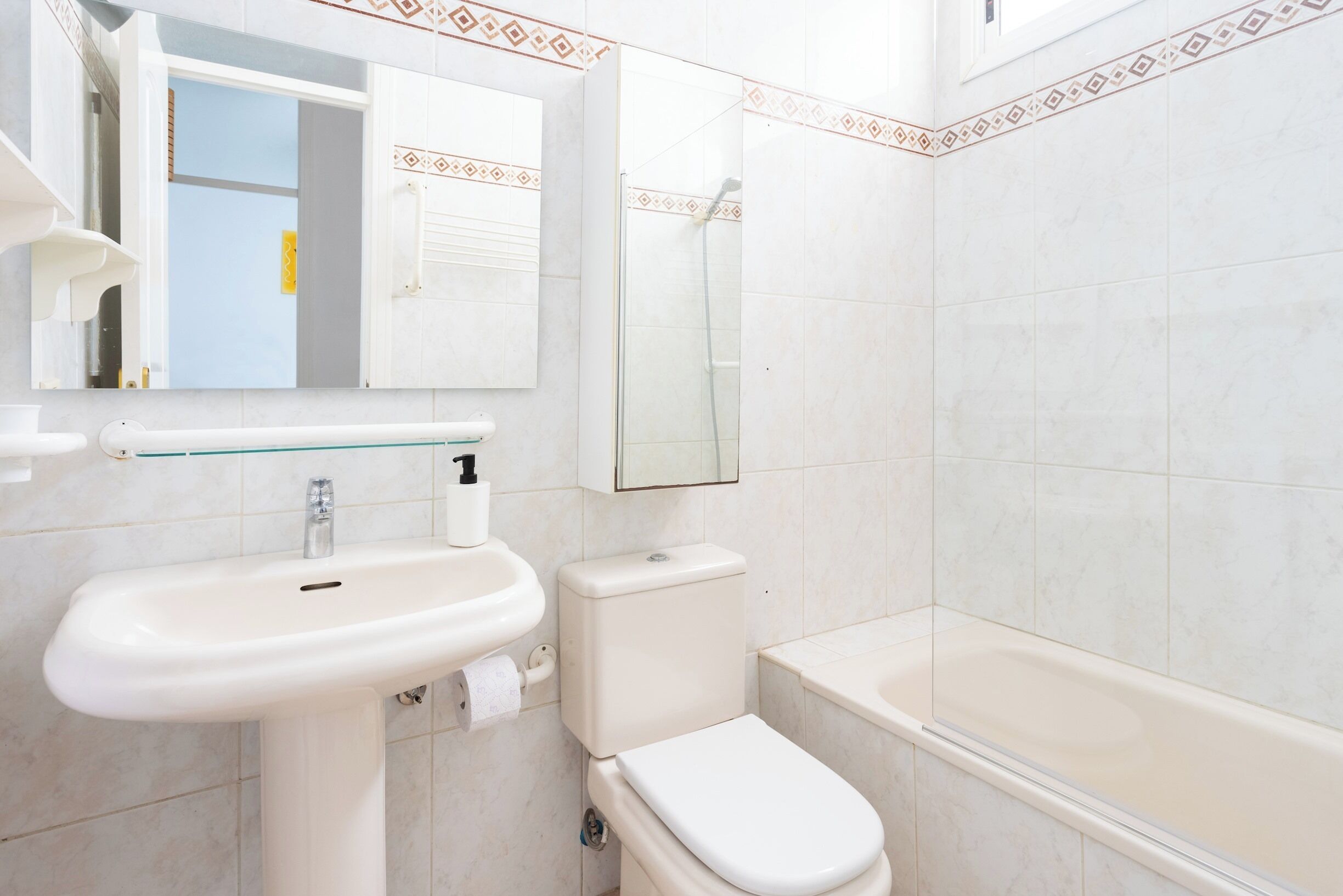 Un baño con lavamanos, inodoro y bañera.