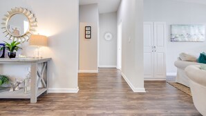 Un salon moderne avec un plancher en bois, un canapé blanc, une table basse et une lampe.