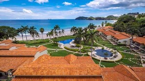 Un complexe hôtelier comprenant plusieurs bâtiments, une piscine et une plage.