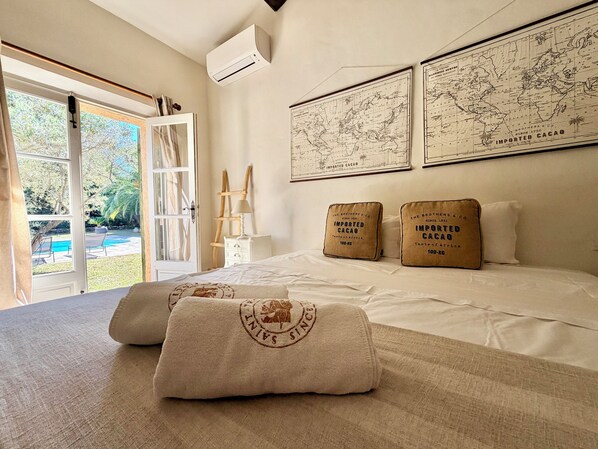Ein Schlafzimmer mit einem großen Bett, zwei Kissen, einem Nachttisch, einer Lampe und einer Karte an der Wand.