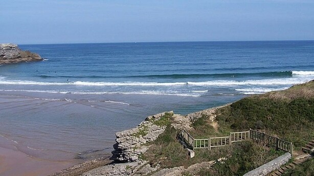 A coastal view with a rocky shoreline, a wooden walkway, and the ocean in the background. - Apartamento en Ajo - Antuerta 12006 (Cantabria)