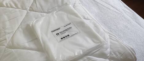 Ein Zimmer mit zwei Einzelbetten, einem Holzregal darüber und einer Steckdose.