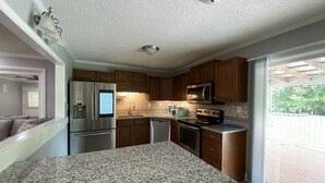 A kitchen with granite countertops, stainless steel appliances, and wooden cabinets.