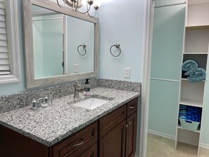 A bathroom with a granite countertop, a sink, a mirror, and a towel rack. - Harrison Bay Hideaway: Cozy home, walk to Harrison Bay State Park, Golf, Lake (Harrison)