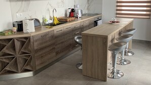 Eine moderne Küche mit einer Holzinsel, Barhocker und einem Einbauofen.