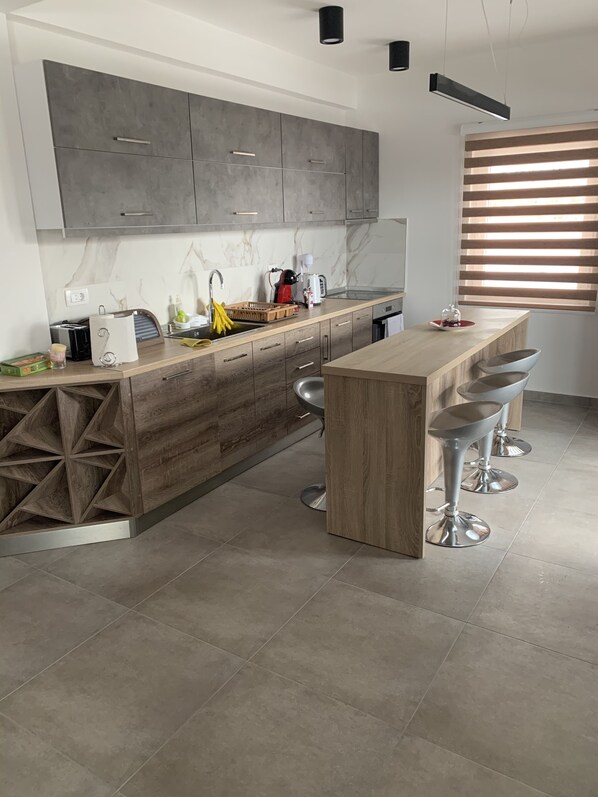A modern kitchen with a wooden island, bar stools, and a built-in oven. - VILLA M WITH PRIVATE POOL,PRIVATE SAUNA & JACUZZI (Lavci)