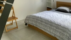 A bedroom with a bed, a wooden ladder, a framed picture on the wall, a window, and a shelf. - Very nice, quiet apartment near the beach (Hyères)