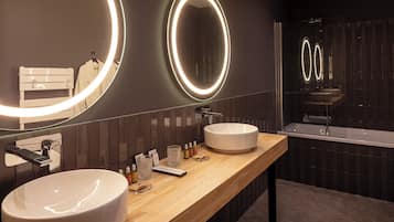 Ein modernes Badezimmer mit einem großen Spiegel, zwei Waschbecken und einer Holzausstattung.
