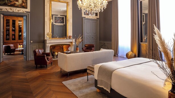 A luxurious bedroom with a large bed, a fireplace, a chandelier, and a classic decor style. - Margaret - Hôtel Chouleur (Nîmes)
