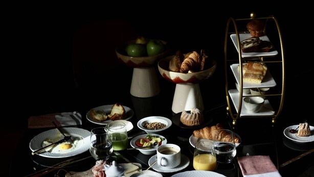 A dining table set with various breakfast items, including pastries, a teapot, and cups. - Margaret - Hôtel Chouleur (Nîmes)